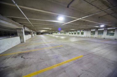 Şehir planlama ve yalnızlığın sembolü olan Fort Wayne, Indiana, 2016 'da geceleri floresan ışığında yıkanan boş şehir otoparkı.