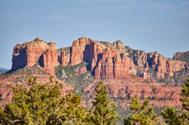 Sedonas canlı kırmızı kaya oluşumları berrak mavi gökyüzü altında, çerçevelenmiş yemyeşil yapraklar, Arizona 2016