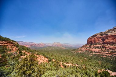Sedona, Arizonas Devils Köprüsü 'ndeki koyu kırmızı kaya oluşumlarına karşı yemyeşil çimlerin canlı gündüz görüntüsü 2016' da Amerika 'nın güneybatısının eşsiz güzelliğini gözler önüne seriyor..