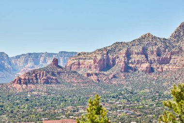 Sedona, Arizona 'daki 2016 manzarası çarpıcı kızıl kaya oluşumları ile sakin bir vadi yerleşimi arasındaki zıtlığı gözler önüne seriyor.