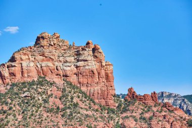 Sedona, Arizona, 2016 'da berrak bir mavi gökyüzü altında canlı kırmızı kaya oluşumlarının gün ışığı - jeolojik harikalar ve çöl güzelliğinin bir kanıtı..