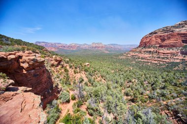 Devils Köprüsü, Sedona, Arizona 'daki yeşil çöl vadisinin panoramik manzarası ve kırmızı kumtaşı oluşumları engebeli doğal güzelliğin ve vahşi doğanın bir sembolü..