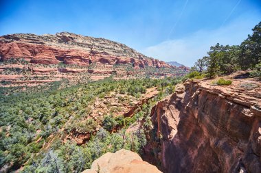 Devils Köprüsü, Sedona, Arizona 'da berrak mavi gökyüzü altında canlı kırmızı kaya oluşumlarının nefes kesen görüntüsü Güneybatı Çölü manzaralarının saf güzelliğini gözler önüne seriyor..
