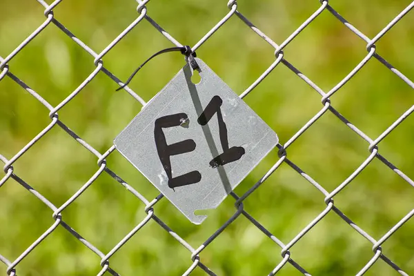 Close View Chain Link Fence Featuring Grey Square Tag Marked — Stock Photo, Image