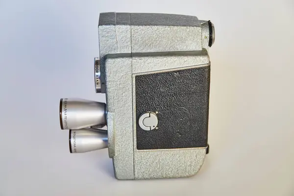 Vintage 8mm film camera, showcasing aged silver and black leatherette details, set against a neutral backdrop. Ideal for themes of nostalgia, filmmaking and technology history.