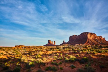 Anıt Vadisi, Arizona, 2016 'da altın saat ışığı altında çarpıcı kızıl kaya oluşumlarıyla nefes kesici çöl manzarası.