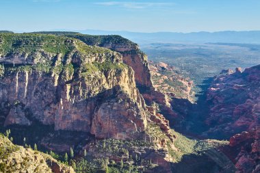 Sedona, Arizona 'daki uçsuz bucaksız kırmızı kaya kanyonunun nefes kesici manzarası gündüz boyunca göz kamaştırıcı güzellikleri sergiliyor.