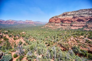 Sedonas ikonik kırmızı kaya oluşumları, yemyeşil vadi bitki örtüsü ve canlı mavi gökyüzü, 2016 Güneybatı manzaralarının macera ve güzelliğinin bir örneği..