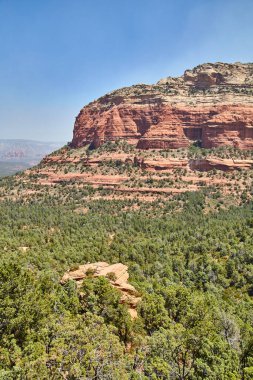 Sedonas Devils Köprüsü, Arizona 2016 'da açık mavi gökyüzünün altında yeşil çöl ortasında çarpıcı bir kızıl kaya oluşumu.