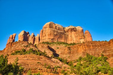 Sedona, Arizona 'daki Katedral Kayası' nın nefes kesici görüntüsü açık mavi gökyüzüne karşı yükselen kızıl kaya oluşumlarını gözler önüne seriyor.
