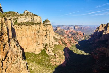 Sedona Kanyonu Gün Işığı Manzarası - Hava 2016 'da Arizonas' ın görkemli, engebeli arazisini canlı tortul kayalıklar ve açık mavi gökyüzü altında uzak dağlar ele geçirildi.