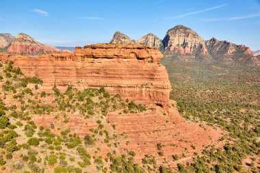 2016 'da Sedona, Arizona' da güneşli, engebeli bir çöl manzarasının canlı görüntüsü düz tepeli bir mesa 'nın jeolojik güzelliğini, yüksek kalçaları ve dayanıklı yüksek çöl bitkilerini gözler önüne seriyor..