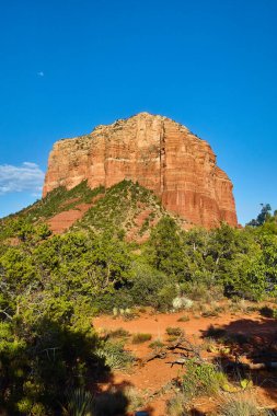 Sedona, Arizona 'da Sunlit Çan Kayası oluşumu, açık mavi gökyüzü altında çöl bitkileriyle çevrili, 2016
