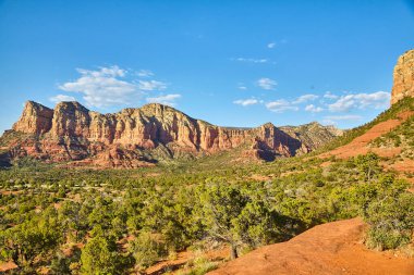 Sedona, Arizona 'da berrak bir gökyüzü altında canlı Bell Rock oluşumlarının geniş bir görüntüsü çöl ekosistemini ve jeolojik tarihi gözler önüne seriyor..
