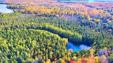 Michigan ormanındaki sonbahar geçişi, sakin göl kenarında gözlerden uzak bir kulübe, DJI Phantom 4 insansız hava aracı tarafından ele geçirildi.