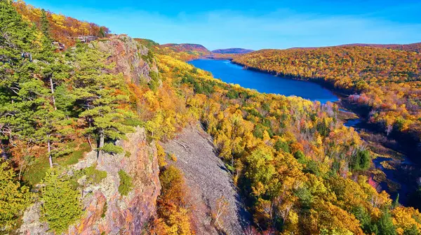 2017 'de Ontonagon County, Michigan' daki bir insansız hava aracı tarafından yüksek bir görüş noktasından yakalanan sakin bir gölü çevreleyen canlı sonbahar yeşilliği.