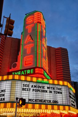 Michigans Devlet Tiyatrosu 'na alacakaranlık düşüyor, neon ışıklı tabelası hareketli bir şehrin köşesinde parlıyor, sinemaseverleri şehirdeki en iyi patlamış mısırın tadını çıkarmaya davet ediyor..