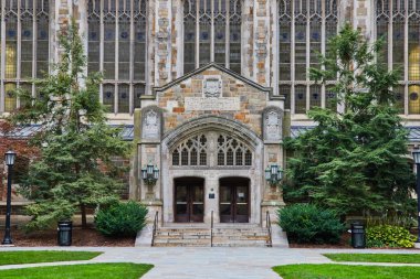 Michigan Üniversitesi Hukuk Fakültesi Karmaşık ahşap kapılar, süslü taş kemer yolu ve çevreleyen yeşillik girişi