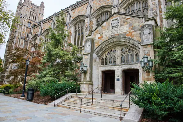 Ann Arbor 'daki Gotik tarzı Michigan Üniversitesi Hukuk Fakültesi Binası girişi zengin taş işçiliği ve yemyeşil alanlarla vurgulanmış..