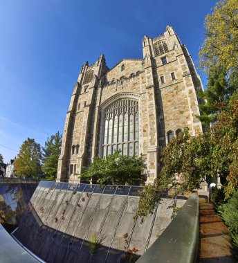 Michigan Üniversitesi Hukuk Fakültesi 'nde Gotik Uyanış Mimarisi Ann Arbor, açık mavi gökyüzü altında sonbahar yeşillikleri ve modern yansımalarla vurgulandı.