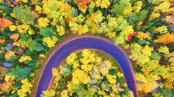 Aerial view of winding road amid autumn splendor in Michigans Copper Harbor, captured by drone in 2017