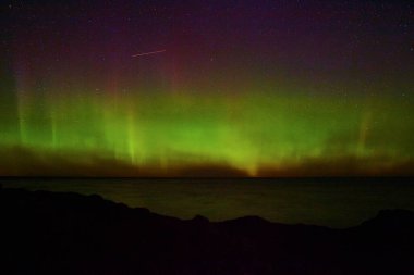 Kuzey Işıkları, Copper Harbor, Michigan 'da sakin bir kıyı şeridinde dans ediyor. Astrofotoğrafçılık yoluyla doğal bir harikayı gözler önüne seriyor..