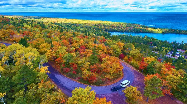 Aerial View of Autumn Splendor in Copper Harbor, Michigan with Scenic Road and Parked Car
