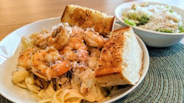 Fort Wayne, Indiana, 2021 'de ev yapımı İtalyan karidesli makarna, kızarmış ekmek ve Sezar salatası.