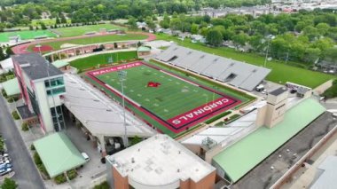 Top State Üniversitesi, Muncie, Indiana 'daki Scheumann Stadyumunun Hava Arc Shot' u belirgin kırmızı ve beyaz renk şeması, canlı atletizm tesisleri ve yerel halka entegrasyonunu gözler önüne seriyor.