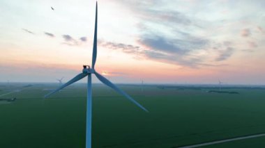 Ohios Green Farmland ve Rüzgar Türbinlerinin Sunrise veya Sunset 'teki hava görüntüsü, Sabit Çekimde Yenilenebilir Enerji ve Sürdürülebilir Tarım Güzelliğini Gösteriyor.