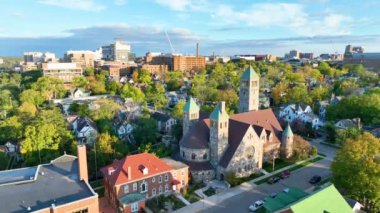 Ann Arbor, Michigan 'da Sunrise' ın hava yürüyüşü. Kentsel genişlemenin ortasında, ikiz dikenli taştan kiliseyi vurgulayan, ilginç bir şehir manzarası üzerinde sıcak renklerin büyüleyici görüntüsü..