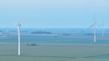 Ohios 'un sakin tarım arazisinin düzlüklerine dik duran etkileyici rüzgar türbinleri yenilenebilir enerji ve tarımsal yeniliği sembolize ediyor..