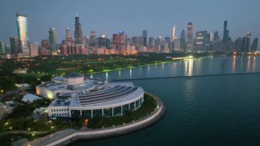 Chicago 'nun havadan görünüşü günden geceye değişiyor. Ön planda Shedd Akvaryumu ve Michigans Gölü' nün sakin suları şehrin ışıklarını yansıtıyor..