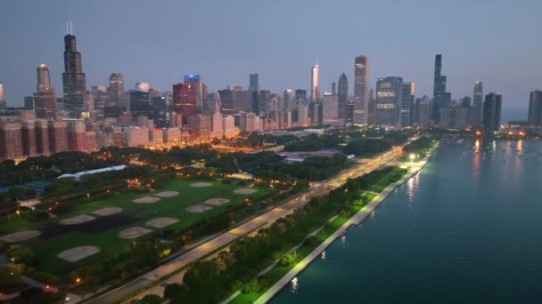 在灯光昏暗的芝加哥上空 空气飘扬 展现了繁华的市中心摩天大楼与宁静的密歇根湖之间的反差 笼罩着城市的活力和宁静 — 图库视频影像
