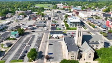 Vibrant Muncie, Indiana 'nın Havadan İzleme Çekimi: Konut ve ticari yapıların dinamik bir karışımını, hareketli caddeleri ve yeşilliğin ortasındaki sembolik kilise kulesini gösteriyor.