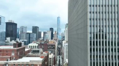 Şikago şehir merkezinin sabah erken saatlerinde hava yayası görüntüsü. Hareketli tren rayları, tarihi binaların ve modern gökdelenlerin karşıtlığını oyuyor..