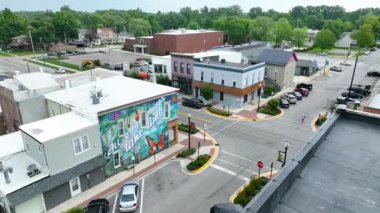 Auburn, Indiana 'nın Aerial Pan Shot' u: Büyüleyici şehir merkezi üzerinde sabahın erken saatlerinde, canlı kelebek duvar resmini, yerel ticaretin telaş ve ikonik DeKalb County 'yi vurguluyor.