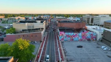 Muncie, Indiana şehir merkezinden uçakla geçerken modern ve tarihi mimarinin ahenkli bir harmanını, hareketli caddeleri ve canlı bir duvar resmini vurguluyor..