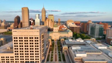 Indianapolis, Indiana 'da, altın saatinde, modern ve tarihsel şehir manzarasının bir karışımı içinde ışıldayan bir Indiana Statehouse' a ev sahipliği yapan.