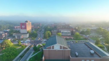 Ball State Üniversitesi, Indiana 'da sakin bir güneşin doğuşunun hava takibi sisli sabah renklerinin ortasındaki huzurlu akademik ortamı vurguluyor..