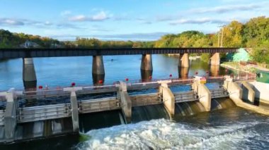 Argo Barajı 'nın Huron River, Michigan' daki hava yayası çekimi, insan mühendisliği ve doğanın uyumunu özetliyor. Şelalenin sakin manzarası, kayakçılar ve parlayan gün batımı..