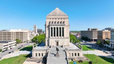 Indianapolis şehir merkezindeki Indiana Savaş Anıtı ve Müzesi 'nin havadan görünüşü, açık mavi gökyüzünün altındaki hareketli şehir manzarası arasında ihtişamlı mimarisini yakalıyor..