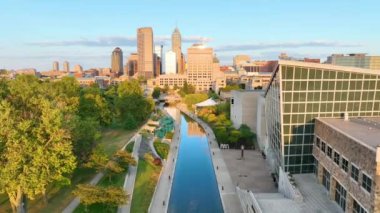 Indianapolis, Indiana şehir merkezinden uçarak geçen ve altın saat boyunca kentsel ufuk çizgisi ve dingin kanalların karışımını gözler önüne seren şehirler canlılık ve sükuneti ön plana çıkarıyor..
