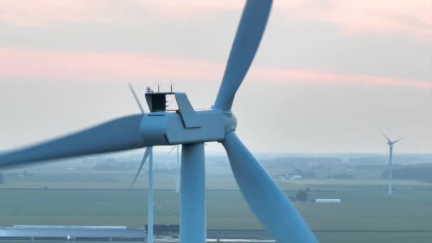エアリアル アーク ショットは オヴァン セリーンの田園地帯で風力タービンの威厳を捉え 持続可能なエネルギーと自然の調和したブレンドを伝えています — ストック動画