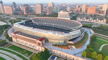 Şikago Iconic Soldier Field in Dusk 'taki hava görüntüsü - Chicago Ayıları' nın tarihi evinin yer aldığı büyüleyici yay çekimi, yayılan kentsel manzaranın ortasına yerleşmiş..