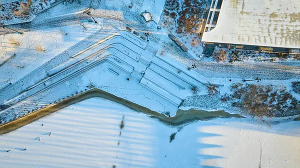Aerial Golden Hour View of Snow-Covered Staircases and Modern Architecture in Downtown Fort Waynes Promenade Park, Winter