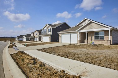 Fort Wayne, Indiana 'da gelişmekte olan bir banliyö mahallesinde Amerikan gayrimenkul gelişiminin sergilendiği günışığıyla aydınlanan yeni evler..