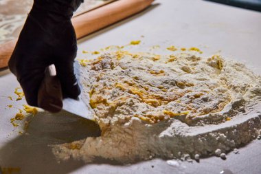 Handcrafted Pasta Preparation in Fort Wayne Kitchen - Skilled Chef Incorporates Fresh Eggs into Flour Mound with Dough Cutter clipart