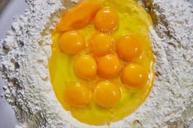 Ev yapımı makarna için taze Indiana yumurtaları ve un hazır. Çiğ pişirme malzemelerinin baştan çıkarıcı bir genel görünümü..