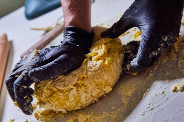 Fort Wayne, Indiana 'daki zanaatkar yemek gemisi eldivenli eller ustalıkla ev yapımı makarna hamuru yoğuruyor.